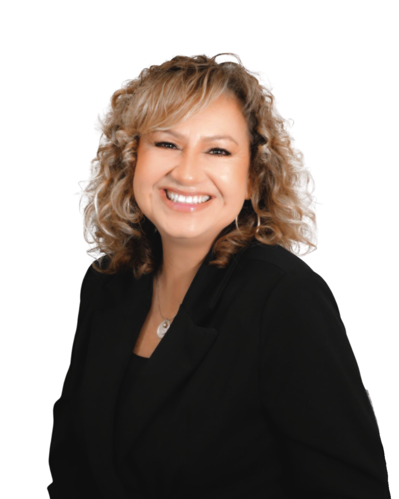 A professional headshot of a woman with curly blonde hair, wearing a black blazer and a pendant necklace. She is smiling and facing the camera against a plain white background.
